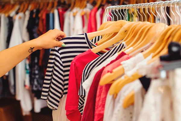 Elbise askıları kadınlar dükkanda renkli giysileri ile. Yaz sa