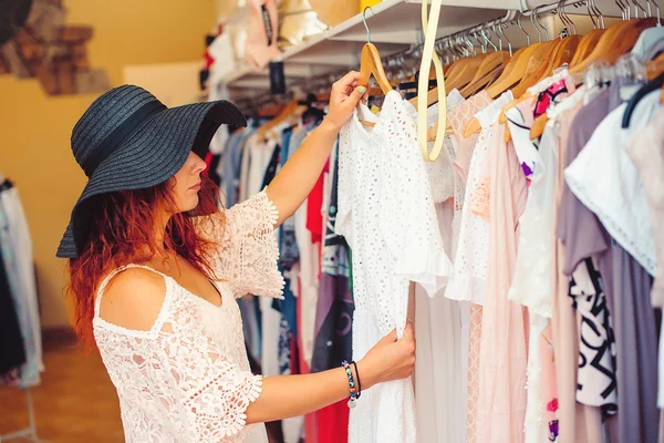 Mujer joven en negro sombrero de compras en la tienda de mujeres. Tiempo de compras . — Foto de Stock