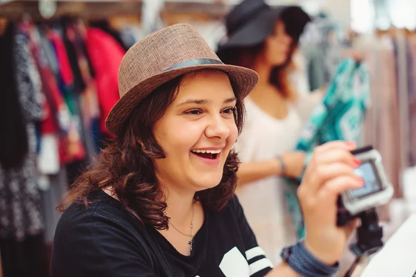 모자 옷 stor에 쇼핑에서 매력적인 젊은 여자를 웃 고 — 스톡 사진