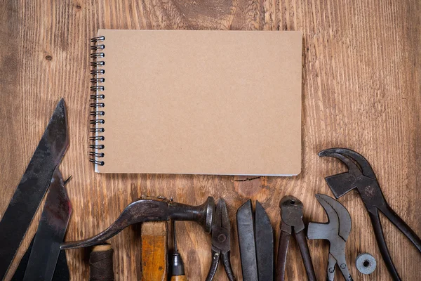 Juego de herramientas y cuaderno para zapatero sobre fondo de madera . —  Fotos de Stock