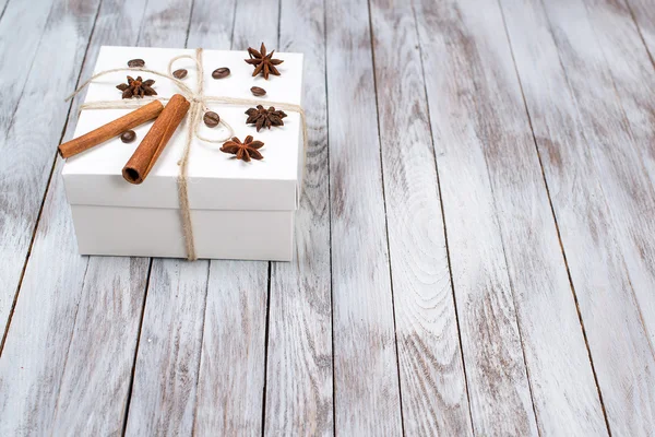 Christmas box decorated by cinnamon, anise, coffee, beans on wooden background.Winter holidays concept. Space for text. — Stock Photo, Image