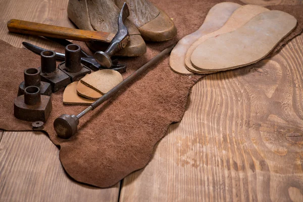 Set de herramientas artesanales de cuero sobre fondo de madera. Lugar de trabajo para zapatero . — Foto de Stock