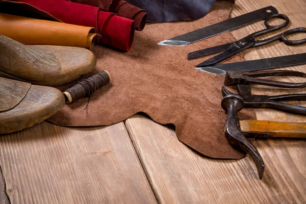 Conjunto de ferramentas de artesanato de couro em fundo de madeira. Local de trabalho para sapateiro . — Fotografia de Stock