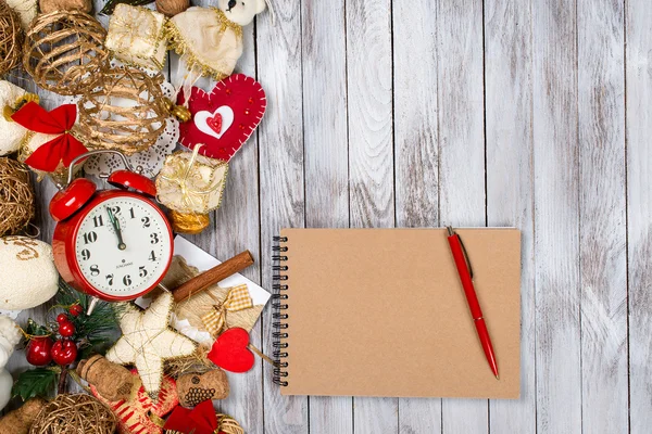 Kerstdecoratie, notebook en pen over houten achtergrond. Winter vakantie concept. Ruimte voor tekst. — Stockfoto