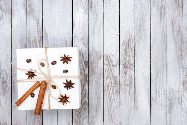 Caja de Navidad decorada con canela, anís, café, frijoles sobre fondo de madera.Concepto de vacaciones de invierno. Espacio para texto . — Foto de Stock