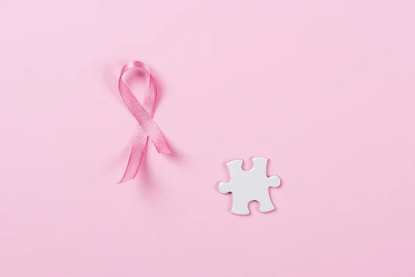 Rakovina prsu růžová stuha a puzzle kousky. — Stock fotografie