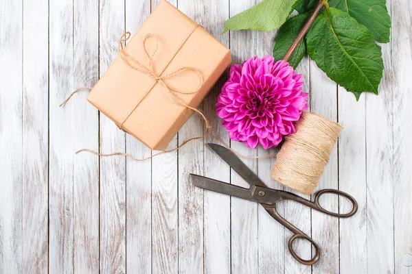 Handcrafted gift box and pink chrysanthemum flower on wooden background. Concept of natural style design. — Stock Photo, Image