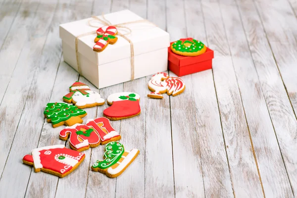 Caixa de presente de Natal com biscoitos de gengibre sobre fundo de madeira branca . — Fotografia de Stock