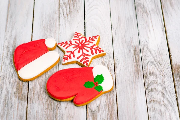 Biscoitos de gengibre coloridos de Natal no fundo de madeira branco . — Fotografia de Stock