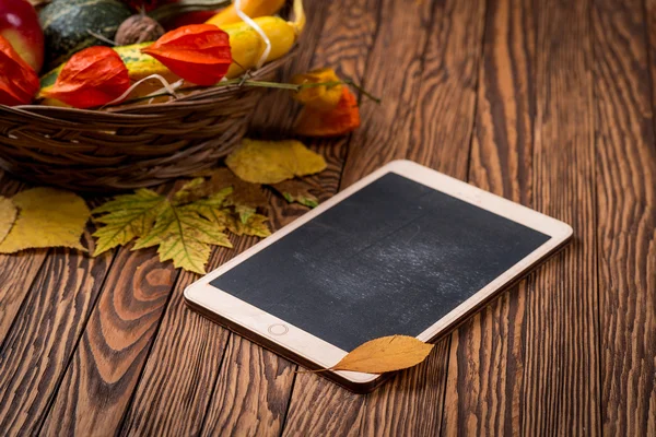 Fondo de otoño y tableta sobre tablas de madera. Espacio para tu texto. Enfoque selectivo . — Foto de Stock