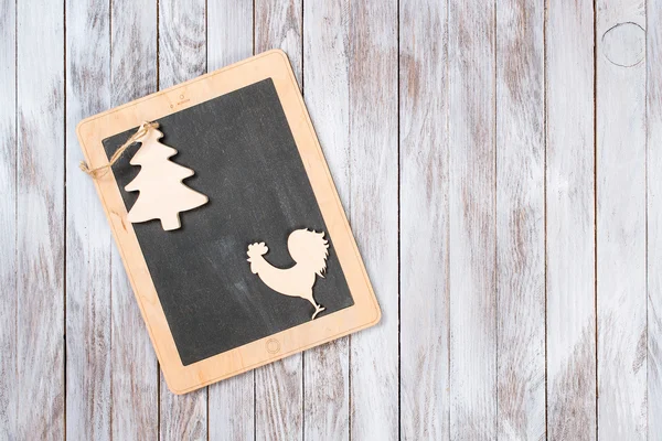 Tablet met Kerstdecoratie op houten achtergrond. Winter vakantie concept. Jaar van de Haan. — Stockfoto