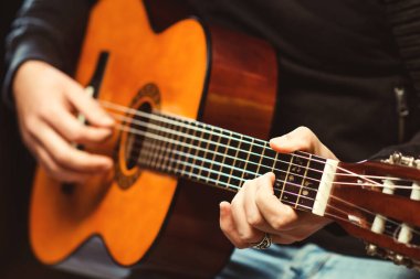 Gitar çalan adamın elleri. Gitarist elinde akustik gitar tutuyor. Barda gitar çalan yakışıklı adam. Gitar çalan hippi. Müzik konsepti. Müzik festivali.