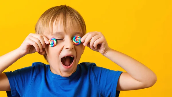 Criança Cobriu Olhos Lolipops Rapaz Animado Bonito Sobre Fundo Amarelo — Fotografia de Stock