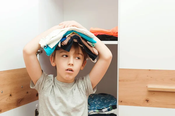 Müder Junge Mit Einem Stapel Kleidung Auf Dem Kopf Kind — Stockfoto
