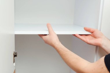 İşçiler dolap rafı kuruyor. Mobilya montajı. Müteahhit modern apartmanda yeni mobilya montajı yapıyor.