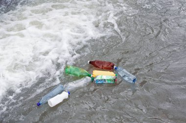 İnsanların bıraktığı plastik şişelerle dolu bir gölet. Su kaynaklarının ekolojik felaketi. Nehir suyundaki plastik şişeler ve çöpler. Çevre kirliliği. Çöp ve israf..