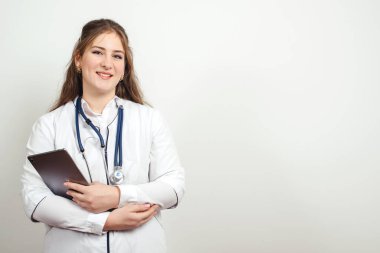 Doktor işte tablet bilgisayar kullanıyor. Sağlık ve ilaç servisi. Steteskoplu genç bir doktor. Modern klinikte sağlık çalışanı. Hastane koridorunda beyaz üniformalı bir kadın doktor..