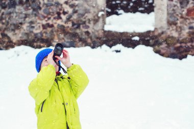 Küçük çocuk monoküler kullanırken bazı şeylere burnunu sokuyor. Eski kalede dolaşan bir çocuk. Kış tatili Mutlu çocukluk.