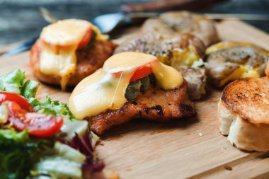 Peynirli fırında tavuk filetosu, fırında patates ve tahta tahtada salata. Hızlı yemek tarifi. Sağlıklı ev yemekleri. Tavuk fileto ile lezzetli bir akşam yemeği..