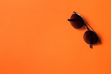 Turuncu kağıtta erkek güneş gözlüğü. Erkekler moda kıyafetleri giyer. Asgari biçim, düz yatış.