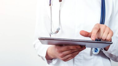 Kadın doktor tablet bilgisayar kullanıyor. Doktor hastanede duruyor. Doktor hasta raporunu okuyor. Fotokopi alanı ile modelleme. Sağlık ve Tıp Hizmetleri.