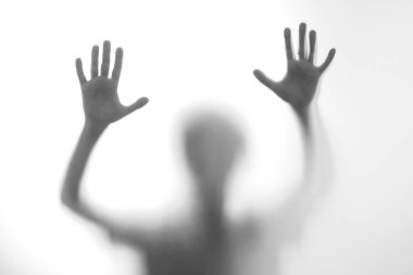 Silüet korkmuş çocuk cam kapının arkasında duruyor. Çocuk iki elini birden gösteriyor. Geçmişi tehlikeli, korku, yardım, musallat olma, korku ve paniği temsil ediyor. Gençlik sorunları, olumsuz duygular kavramı.