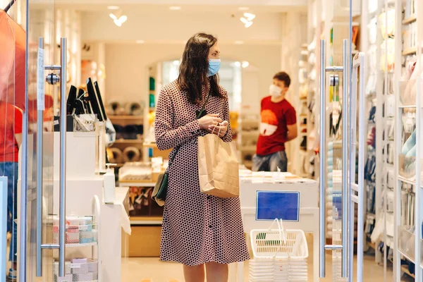 ショッピング中に安全面マスクを着用する女性 モール内にショッピングバッグを持つ若い女性 ファッション ショッピング ライフスタイルのコンセプト 2019年の流行 パンデミックの間の新しい現実は — ストック写真