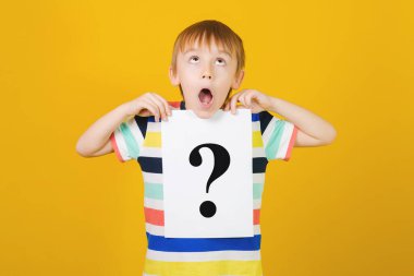 Soru işareti olan hoş, düşünceli bir çocuk. Öğrenci çocuk soru işareti gösteriyor. Tatlı küçük çocuk soru soruyor. Çocuk fikirleri ve beyin fırtınası. Eğitim ve Geliştirme.