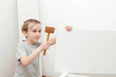 Çocuk kendisi bir kitaplık kuruyor. Oğlu evde yeni mobilya montajı için babasına yardım ediyor. Mobilya montajı..