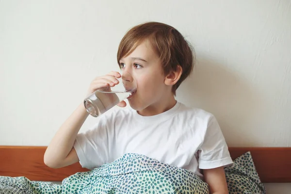 Lindo Chico Bebiendo Agua Fresca Cama Casa Colegial Sosteniendo Vaso — Foto de Stock