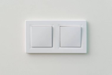 Duvarda beyaz ışık düğmesi var. Aç ya da ışıkları kapat. Duvara monte edilmiş çift lamba anahtarı