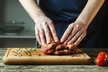 Şefin elleri biftek pişiriyor. Şef çiğ ete tuz ve biber ekliyor. Adam mutfakta biftek pişiriyor. Tahtada biftek pişiriyorum..