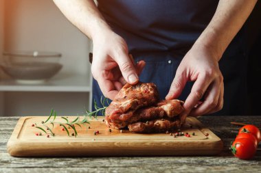 Şefin elleri biftek pişiriyor. Şef çiğ ete tuz ve biber ekliyor. Adam mutfakta biftek pişiriyor. Tahtada biftek pişiriyorum..