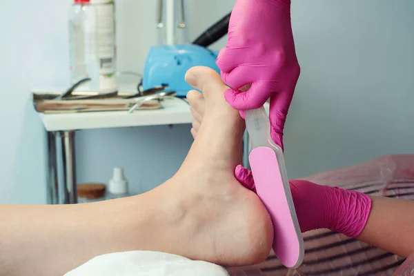 Peeling feet pedicure procedure, closeup. Pedicure and foot care treatment. Professional pedicure in the beauty salon. Woman relaxing at salon, caring about nails.