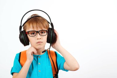 Gözlüklü, kulaklık takan, mikrofonlu, beyaz tenli bir çocuk. Uzaktan eğitim. Covid-19 karantinası sırasında çevrimiçi okul. Operatör kulaklığı takan okul çocuğu..