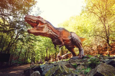 Çocuklar için turistik bir yer. Dinozor parkındaki dinozor. Yaz kampı, tatil ve hafta sonu. Çocuklar için dinozorlu popüler bir yer. Büyük modern dino parkı.