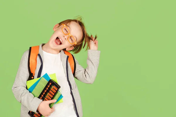 绿色背景下有趣的学童 戴眼镜 背着背包和笔记本的快乐孩子 回到学校和教育 班里的学生 小学教育 — 图库照片