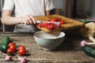 Şef salata için sebze doğruyor. Oğlum aile yemeği için sağlıklı yemek hazırlıyor. Sağlıklı beslenme, diyet konsepti. Aşçı mutfakta..