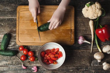 Şef salata için sebze doğrama tahtasının üstünde, manzaralı. Oğlum aile yemeği için sağlıklı yemek hazırlıyor. Sağlıklı beslenme, diyet konsepti. Aşçı mutfakta..
