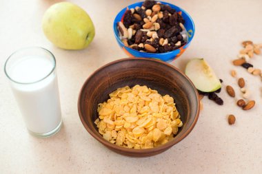 Bir bardak süt ve bir kase kuru müsli. Sağlıklı kahvaltı için gerekli malzemeler. Fitness menüsü için sağlıklı yiyecekler. Kuru kahvaltı gevrekleri. Sağlıklı ve lifli yiyecekler. Kahvaltı zamanı..