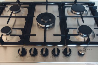 Mutfak gaz ocağı, kapatın. Modern mutfakta yeni gaz sobası ve tezgah yüzeyi. Modern mutfak fırını aşçısı..