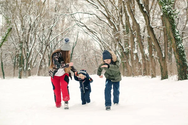 妈妈带着孩子们在冬季公园散步时很开心 冬天的雪天 圣诞佳节快乐 家庭寒假 快乐的家庭在户外与雪玩耍 快乐的童年 — 图库照片