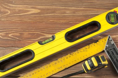 Ahşap masa, araçlar kümesi. Çizgi İnşaat seviyesi ve kare ölçme metre cetvel bakım kavramı