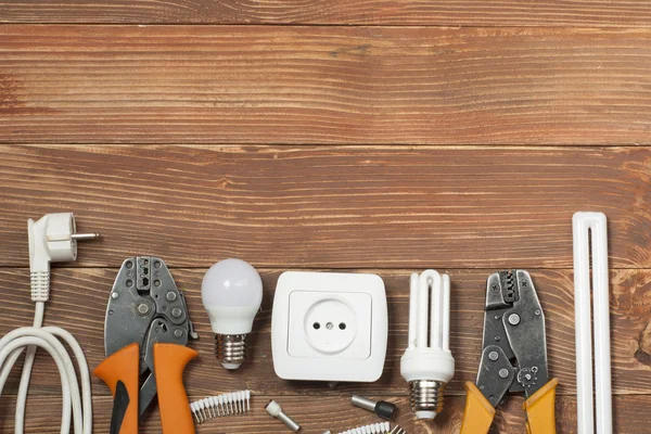 Set di utensili elettrici su sfondo in legno. Accessori per lavori di ingegneria, concetto di energia . — Foto Stock