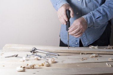 Marangoz uçak ile şantiye, ahşap arka plan üzerinde çalışıyor. Marangoz işyeri