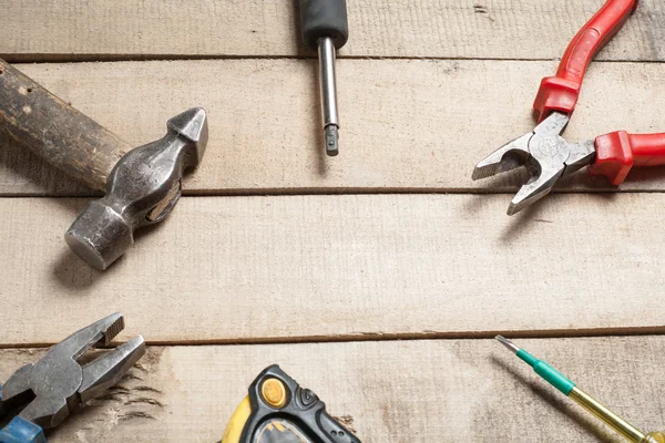 De hulpmiddelen van de bouw op houten achtergrond. Ruimte voor tekst kopiëren. Set van geassorteerde werk hulpmiddel op houten tafel. Bovenaanzicht — Stockfoto