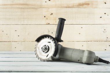 Electric circular saw on wood background. Copy space for text clipart