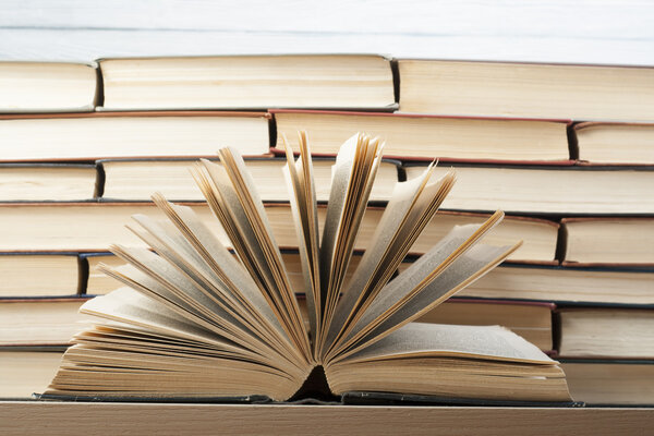 Open book, hardback books on wooden table. Education background. Back to school. Copy space for text.