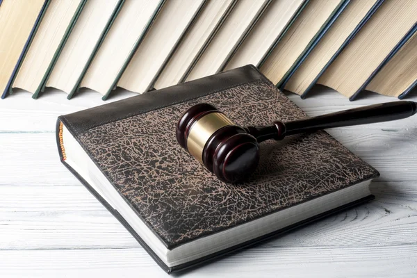 Gesetzeskonzept - Buch mit hölzernen Richterschwingen auf dem Tisch im Gerichtssaal oder Vollstreckungsbüro. — Stockfoto