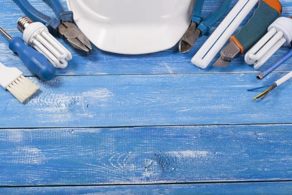 Set di utensili elettrici su sfondo in legno. Accessori per lavori di ingegneria, concetto di energia . — Foto Stock